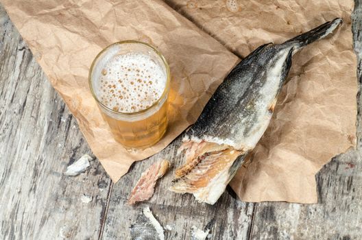 Dry fish with beer on wrapping paper