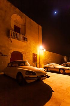 MDINA, MALTA - February 19, 2010. Old timer cars parked near stony buildings of Mdina, ancient capital of Malta.