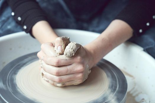 Woman making ceramic pottery on wheel, hands close-up, creation of ceramic ware. Handwork, craft, manual labor, buisness. Earn extra money, turning hobbies into cash and turning passion into job