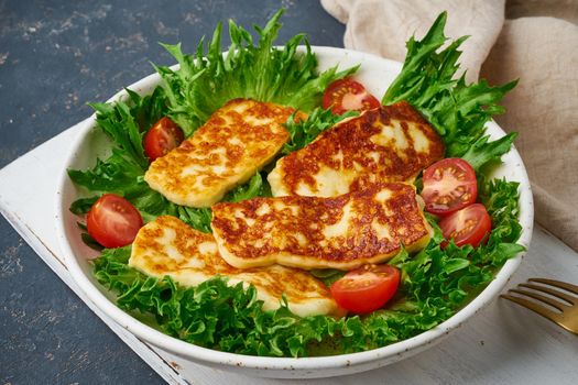 Healthy salad with fried halloumi and tomatoes, closeup, keto ketogenic diet