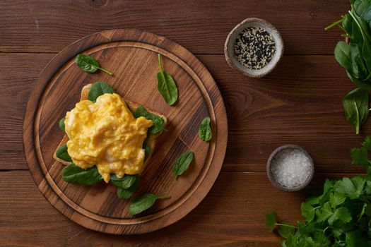 Toast with scrambled eggs and spinach. Omelette. Breakfast with pan-fried eggs