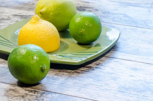 Lemons and limes on a green plate