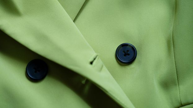 Green stylish suit with black buttons closeup