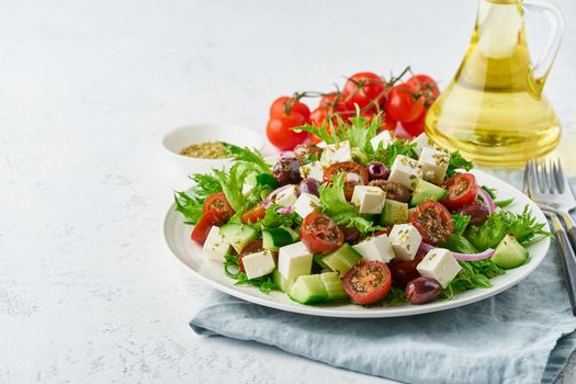 Greek Salad with feta and tomatoes, dieting food on white background copy space closeup