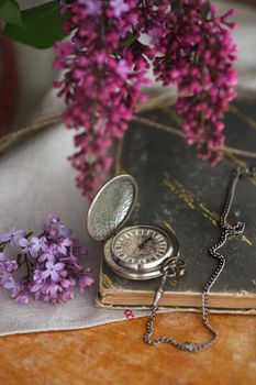 Old pocket watches and lilac flowers.