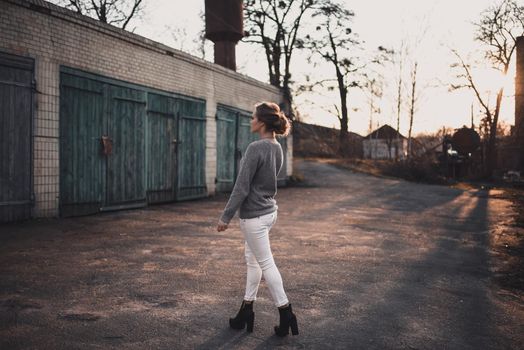 woman with hair tied in a bun in gray knitted sweater On the Sunset
