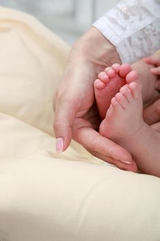 baby foot in mother's hands with care