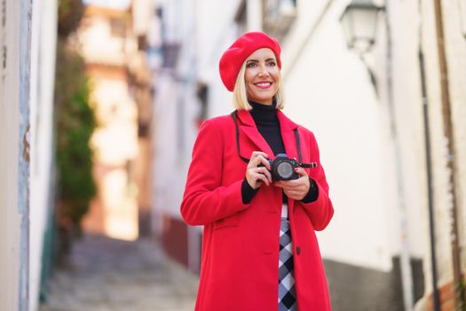 Happy female tourist taking photos of town streets