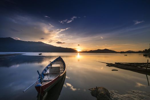 Wooden boats on the shore of a lake at sunset, small wooden boats parked on the shore of the lake