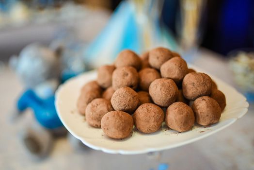 Sweet truffles on a plate covered with cocoa.