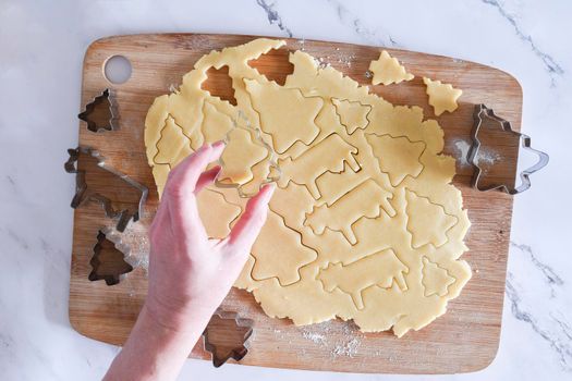 the process of cutting figures from shortcrust pastry for Christmas cookies