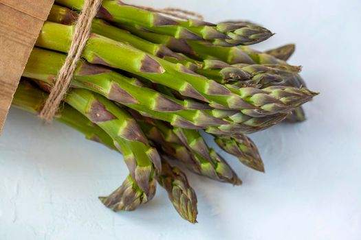 Bunch of fresh asparagus diagonal on the light blue background
