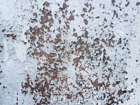 Shabby texture of old metal rusty wall with peeling paint. Textured background with light blue color.