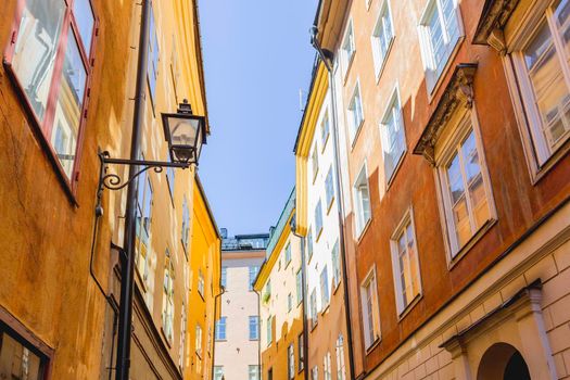 Bright sun reflections on narrow street in historical part of Stockholm. Old fashioned building in Gamla stan, old part of Stockholm, Sweden.