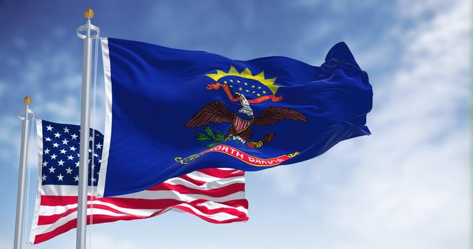 The North Dakota state flag waving along with the national flag of the United States of America