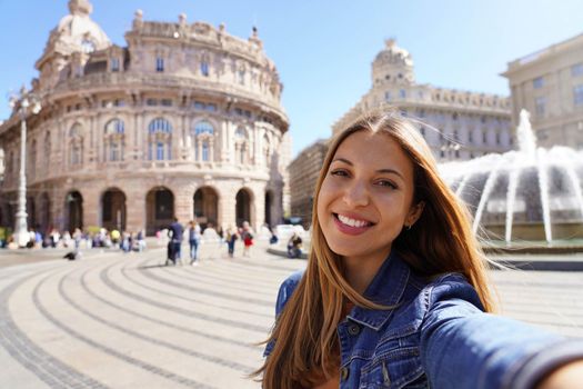 Young smiling woman taking self portrait in Genoa city, Italy