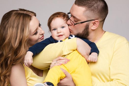 Family in yellow outfit posing on isolated background