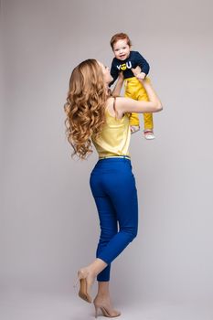 Young and fit woman in casual clothes holding little kid.