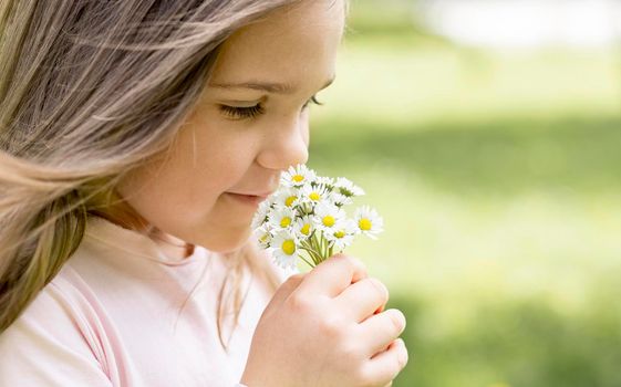 close up girl smelling bouquet field flowers