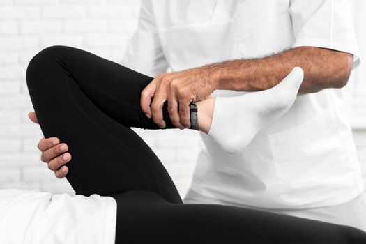 male physiotherapist checking woman s leg mobility