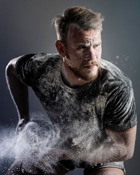 front view athletic male rugby player holding ball with dust