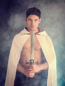 Handsome man in old fashioned cloak with sword