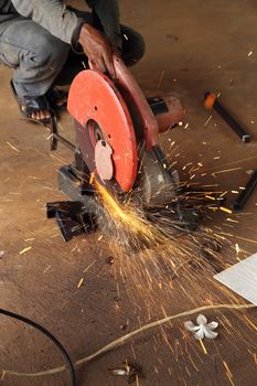 Worker cutting metal and spark 