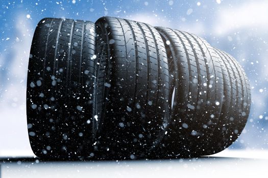 Four car tires rolling on a snow covered road