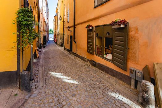 STOCKHOLM, SWEDEN - July 06, 2017. Bright sun reflections on narrow street in historic part of Stockholm. Old fashioned building in Gamla stan, old part of town.