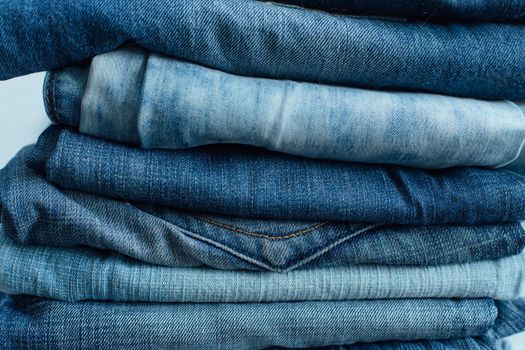 Stack of a stack of old jeans various shades of blue jeans. Denim jeans texture. Denim background texture for design. Canvas denim texture.