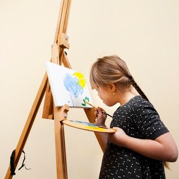 side view girl with down syndrome painting with brush