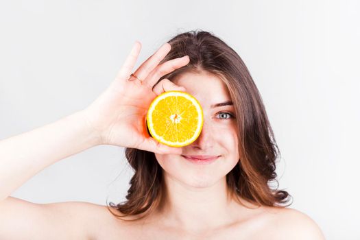 smiling woman holding orange slice face