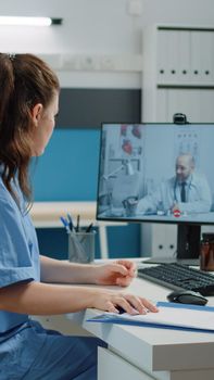 Nurse talking to doctor on video call for professional advice