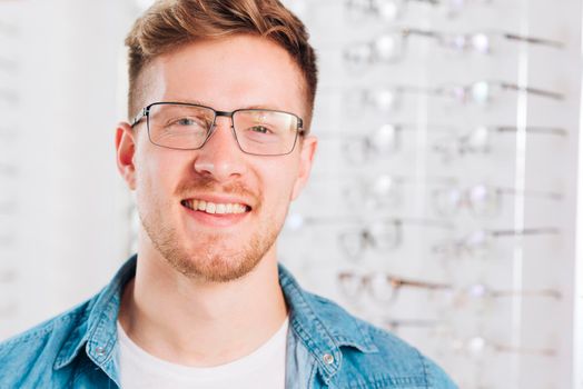 man looking new glasses optometrist