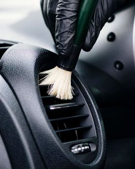 close up person cleaning car interior