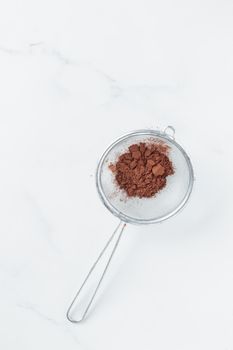 Cocoa powder sweet ingredient in a strainer