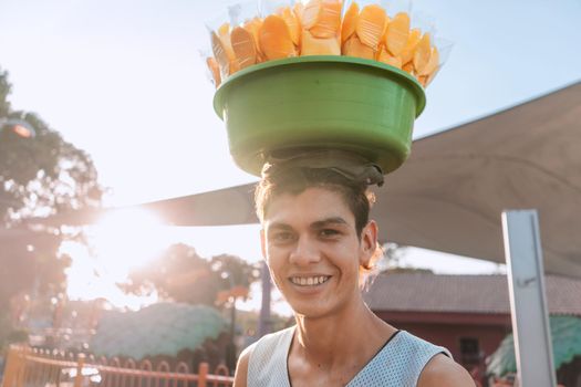 Portrait of a young white latin man street vendor selling mangoes at sunset in Managua, Nicaragua