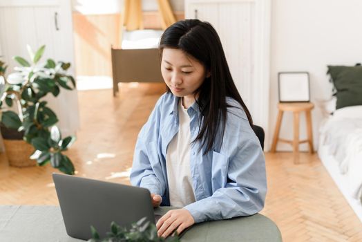 Business asian woman working on laptop at home. Small business owner or freelancer is trained in a home environment