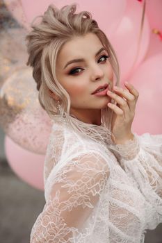 Gorgeous blonde girl with pink air balloons.
