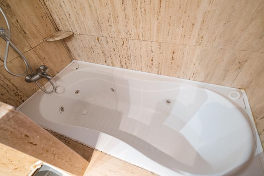 Empty and old jacuzzi bath tube in bathroom interior of a flat