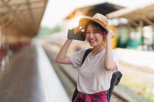 Pretty Young traveler woman excite and planning trip at train station. Summer and travel lifestyle concept.