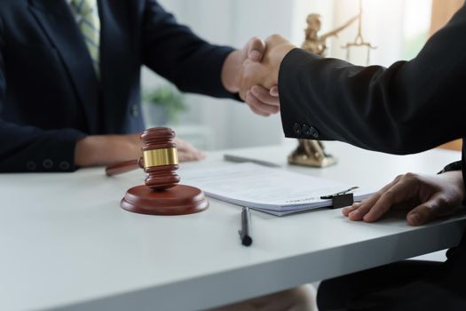 Law, consultation, agreement, contract, lawyer or attorney shakes hands to agree on the client's offer to be hired to fight the parties in court.