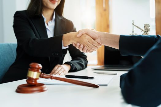 Law, consultation, agreement, contract, lawyer or attorney shakes hands to agree on the client's offer to be hired to fight the parties in court.