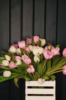 Fresh colorful tulip flowers on dark stone table.