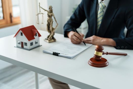 Law, Consultation, Agreement, Contract, Concept Attorney or lawyer focusing on the court hammer is sitting on the chair with a client's complaint to determine the house and land in court