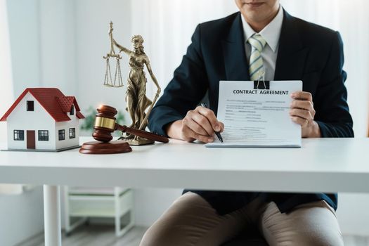 Law, Consultation, Agreement, Contract, Concept Attorney or lawyer holding pen pointing document is sitting on the chair with a client's complaint to determine the house and land in court