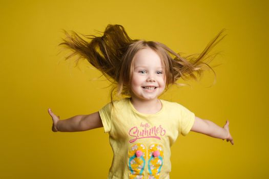 Longhaired girl in cute shirt playing with hair and twirling