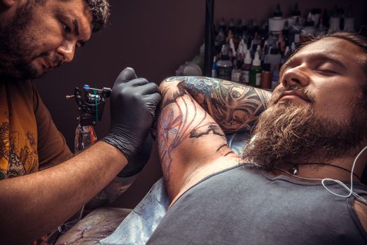 Professional tattoo artist create tattoo in tattoo parlor