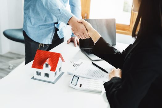 Laws, contracts, mortgages, clients join hands with real estate agents congratulating real estate agents on home and land purchase agreements with insurance to reduce risks during home installments