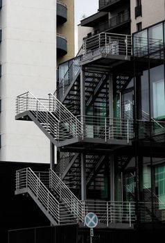 Modern metal stairs on the side of a modern glass building